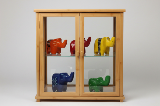A collection of five hand-carved soapstone elephant figurines in assorted colors including orange, red, yellow, blue, and green.