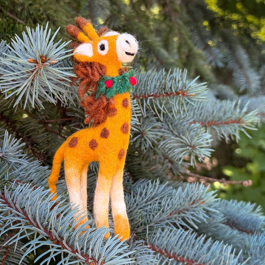 Decorative giraffe ornament with a wreath on a Christmas tree branch