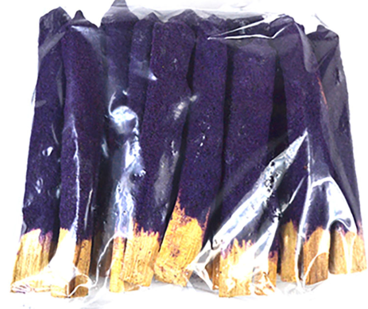 Purple candles with gold bases in clear packaging on a white background