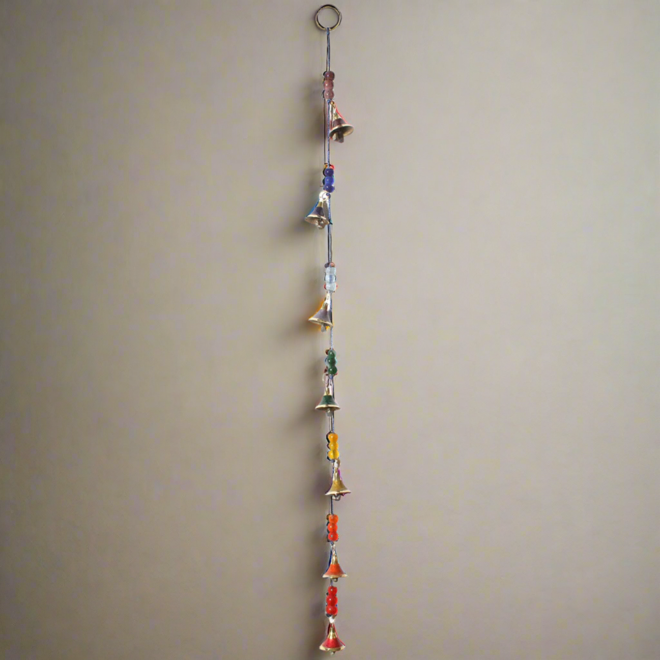 long strand of hanging chakra colored bells and beads.