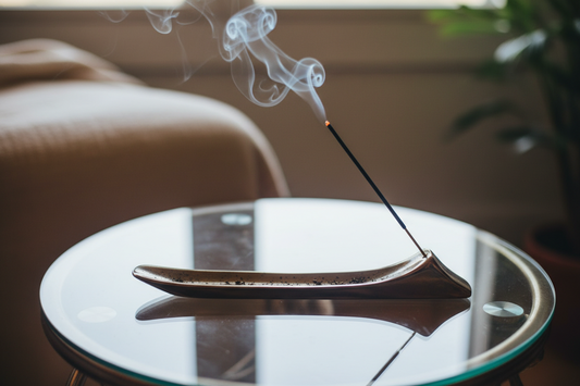 Incense stick with smoke on a glass surface