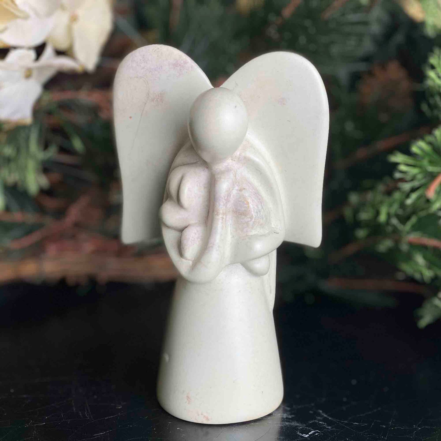 Escultura de esteatita de ángel sosteniendo un perro
