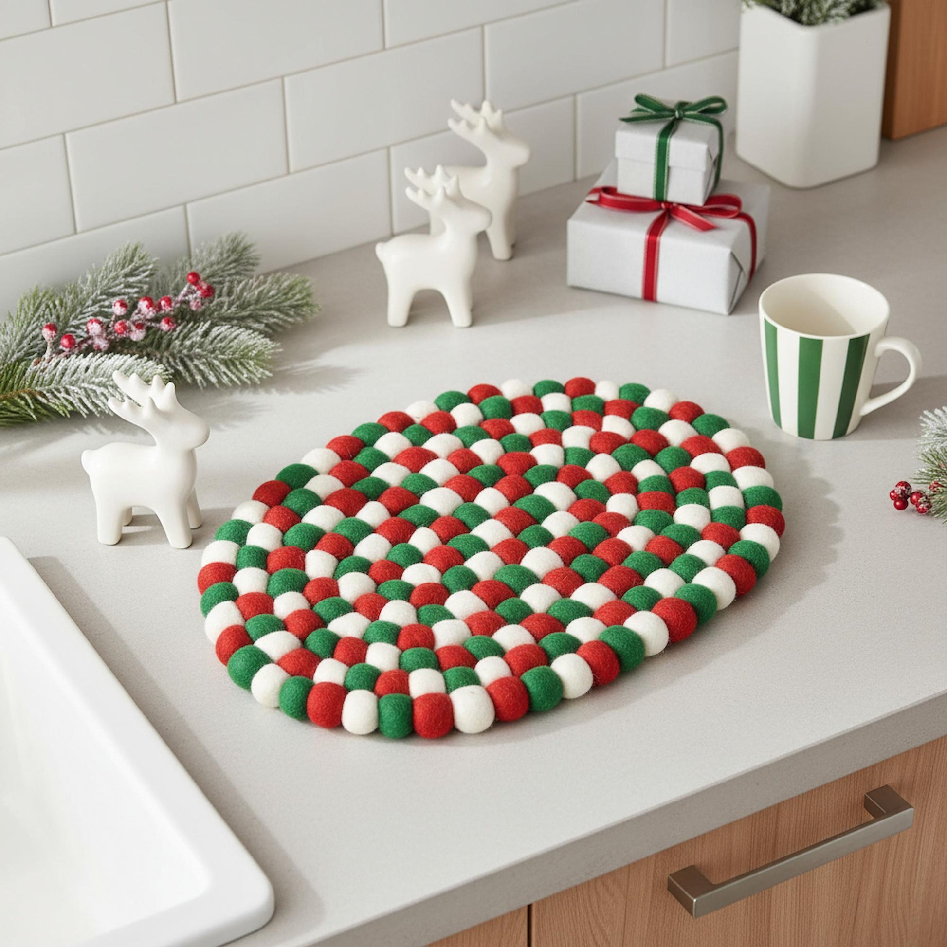 Colorful woven trivet on a kitchen counter with decorative items.