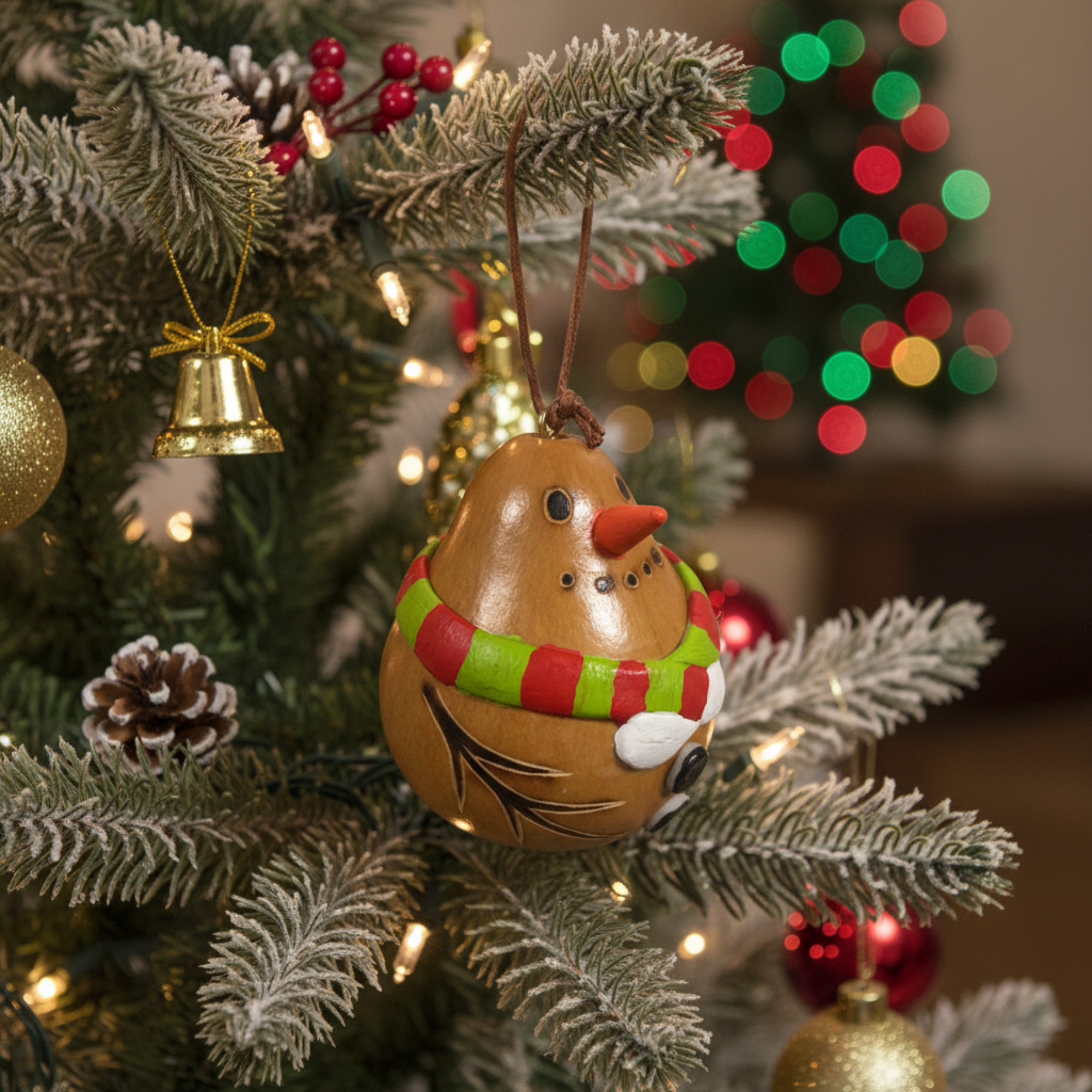 Decorative gourd ornament with a snowman design on a Christmas tree.