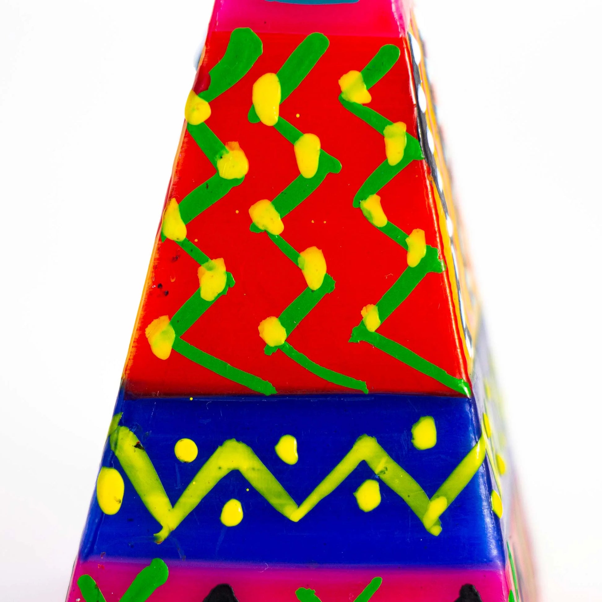 Colorful geometric patterned object with red, blue, green, and yellow colors on a white background.