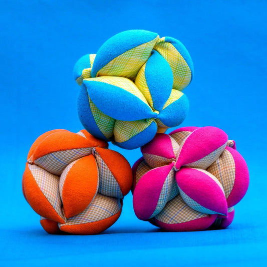 soft puzzle balls for children in blue, orange, and pink