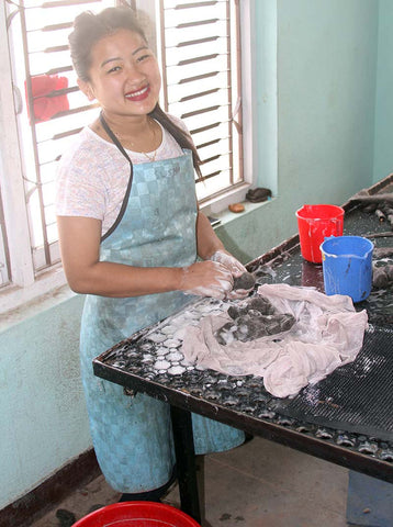 Nepalese female artisan hand making recycled wool to create felt.