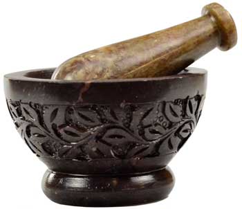 Dark brown soapstone mortar and pestle with intricate floral carvings on a white background.