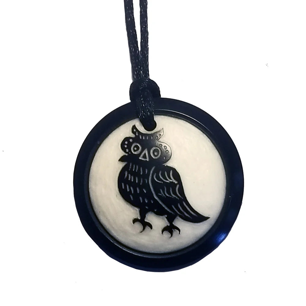Necklace with round pendant made from vegan ivory featuring a hand-carved owl on a white background
