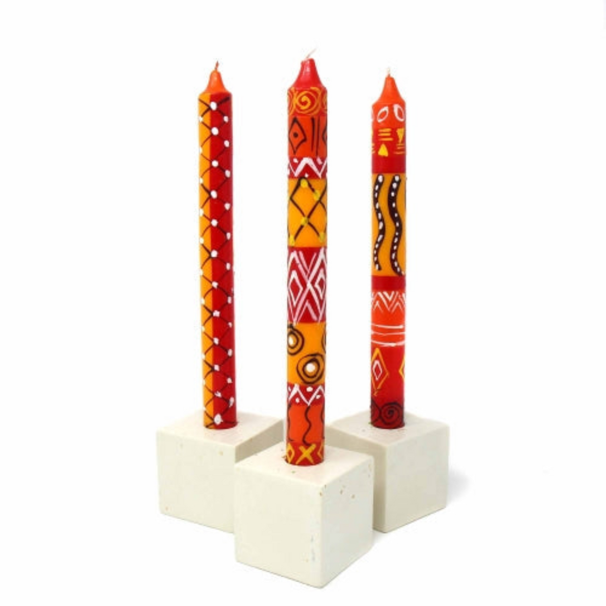 Three South African hand-painted  candles in a white holder on a white background