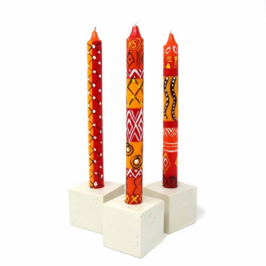 Three South African hand-painted  candles in a white holder on a white background