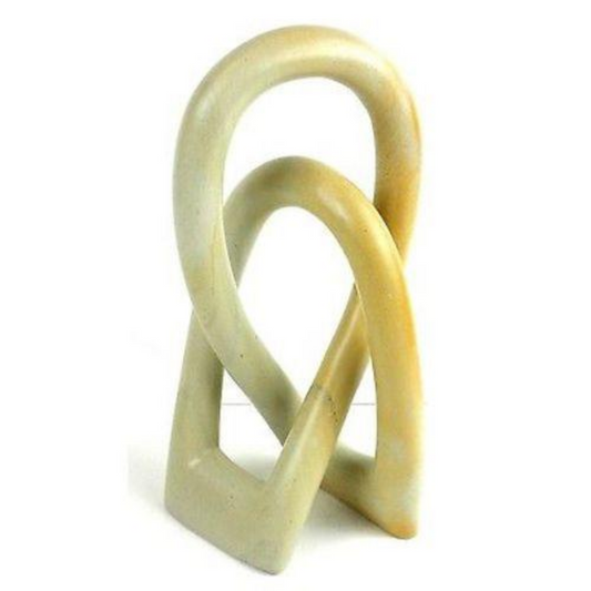 A beige soapstone sculpture of two abstract, intertwined figures representing a loving bond between two souls.