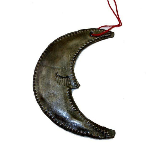 A handmade steel drum ornament in the shape of a moon with a red ribbon, showcasing traditional Haitian metal craftsmanship.